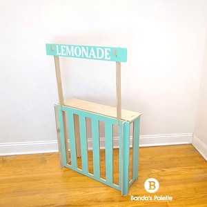 May include: A wooden lemonade stand painted light blue with a sign that reads 