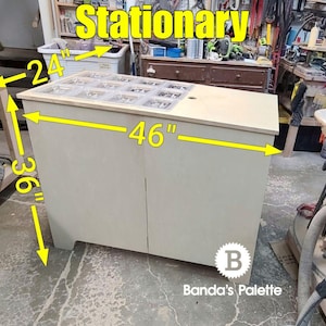May include: A light wood stationary organiser with a clear top and two doors. The organiser is 46 inches wide, 36 inches tall, and 24 inches deep.