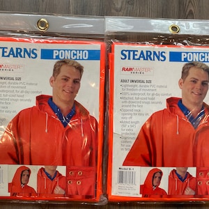 May include: Two orange rain ponchos with the brand name Stearns Rainmaster printed on the packaging. The ponchos are adult universal size and feature a zippered neck opening, a full-sized hood with a drawcord, and grommets at the corners.