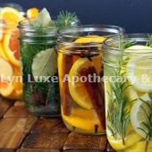 May include: Five glass mason jars filled with ingredients for aromatherapy or home fragrance. The jars contain citrus slices, herbs, and spices. The jars are arranged in a row, with the text "DarLyn Luxe Apothecary & Co" visible.