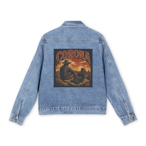 May include: A light blue denim jacket with a rectangular graphic on the back. The graphic features a cowboy sitting in front of a sunset with the word "CORONA" in a vintage font.