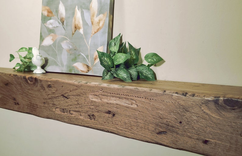 Puede incluir: Una estanter&iacute;a de madera r&uacute;stica con un acabado de madera natural. La estanter&iacute;a est&aacute; decorada con una pintura de hojas y una peque&ntilde;a figurita de p&aacute;jaro blanco.