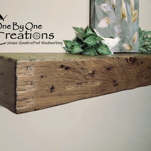 Puede incluir: Una estanter&iacute;a de madera r&uacute;stica con un acabado marr&oacute;n natural. La estanter&iacute;a est&aacute; hecha de madera recuperada y tiene un aspecto &uacute;nico y artesanal. La estanter&iacute;a est&aacute; montada en una pared blanca y tiene una peque&ntilde;a planta y una figurita de p&aacute;jaro en la parte superior.
