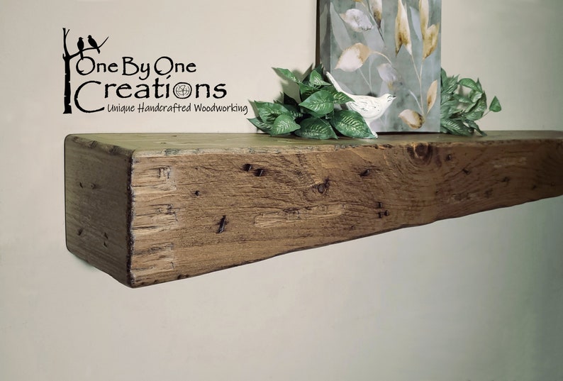 Puede incluir: Una estanter&iacute;a de madera r&uacute;stica con un acabado marr&oacute;n natural. La estanter&iacute;a est&aacute; hecha de madera recuperada y tiene un aspecto &uacute;nico y artesanal. La estanter&iacute;a est&aacute; montada en una pared blanca y tiene una peque&ntilde;a planta y una figurita de p&aacute;jaro en la parte superior.