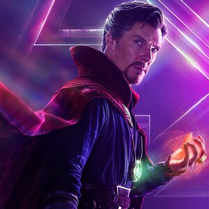 May include: A man wearing a dark blue and red robe with a green pendant and a gold ring on his finger. He is holding a glowing orb in his right hand. The background is a purple and pink geometric pattern.