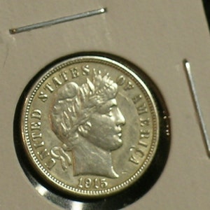 May include: A silver US dime coin with the words "United States of America" and the year "1945" inscribed on it. The coin features a portrait of a woman with a crown on her head.