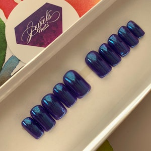 May include: Set of ten blue and purple iridescent press-on nails in a square shape.