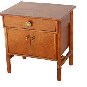 May include: A wooden nightstand with a single drawer and two doors. The nightstand has a light brown finish and is made of bamboo.