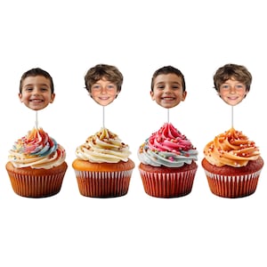 May include: Four cupcakes with different colored frosting and sprinkles. Each cupcake has a photo of a smiling child attached to a stick. The frosting colors include pink, orange, blue, and white.