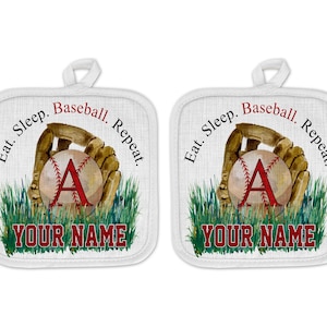 May include: Two white pot holders with a baseball glove and ball design. The text on the pot holders reads "Eat. Sleep. Baseball. Repeat." and "YOUR NAME".