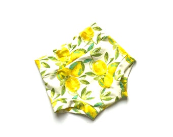 May include: White cotton baby bloomers with a lemon print. The lemons are yellow with green leaves.