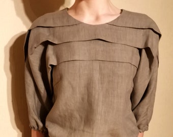 Top en lin plié beige, boutons noirs au dos, demi-manche