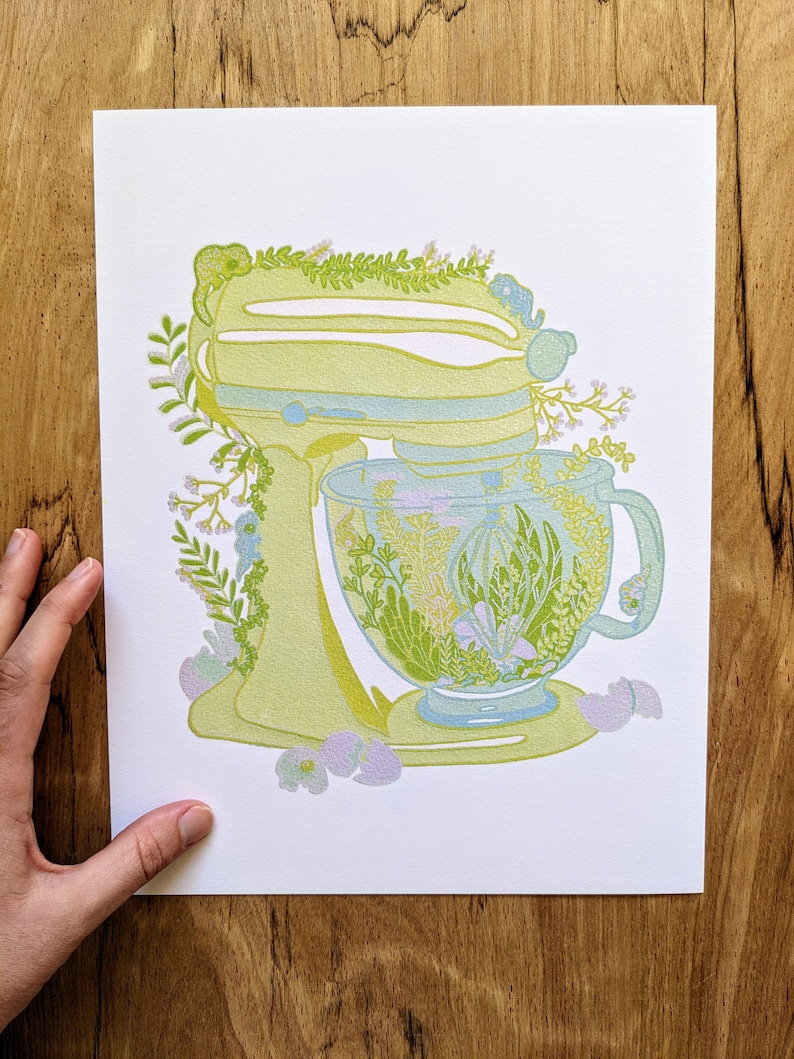 May include: A yellow stand mixer with a green floral design and a matching green floral teacup and saucer.