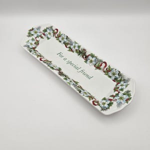 May include: White rectangular serving dish with a green, red, and white floral border. The dish has the words "For a special friend" written in green.