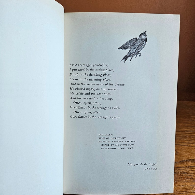 May include: A black and white illustration of a bird singing. The text below the image reads "I saw a stranger yestere'en; I put food in the eating place, Drink in the drinking place, Music in the listening place; And in the sacred name of the Triune He blessed myself and my house My cattle and my dear ones. And the lark said in her song, Often, often, often, Goes Christ in the stranger's guise. Often, often, often, Goes Christ in the stranger's guise. OLD GAELIC RUNE OF HOSPITALITY FOUND BY KENNETH MACLEOD COPIED BY ME FROM BOOK IN SKEABOST HOUSE, SKYE Marguerite de Angeli JUNE 1954"