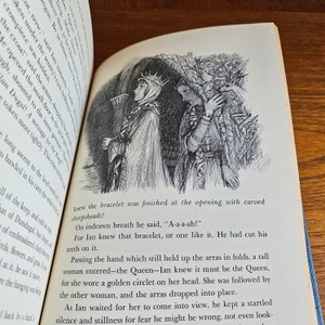 May include: A black and white illustration of a woman wearing a crown and a long robe, standing next to another woman wearing a long robe. The women are standing in front of a dark, leafy background. The text "A-a-a-ah!" is written below the image.