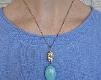 Oval Turquoise Colored Stone Pendant on a Gold Tone Chain
