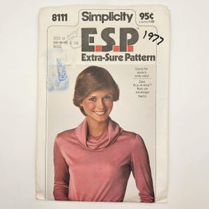 May include: Vintage Simplicity sewing pattern 8111, featuring the text "ESP Extra-Sure Pattern." The pattern cover shows a woman wearing a pink cowl-neck top. The text "1977" is handwritten on the upper right corner.