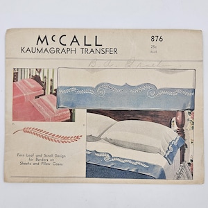 May include: Vintage McCall Kaumagraph transfer for sheets and pillowcases. The design features a fern leaf and scroll pattern in blue. The image shows a bed with the design on the sheets and pillowcases. The transfer is marked with the number 876.