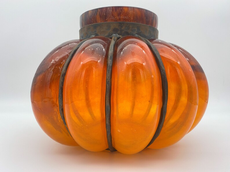 May include: Orange glass pumpkin-shaped lampshade with a metal frame.
