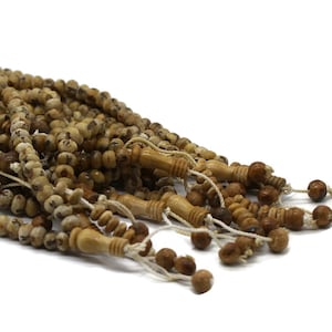 May include: A set of brown wooden prayer beads with a speckled pattern. The beads are strung on a thin cord and have a tassel at the end.
