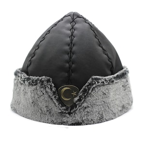 May include: A black faux leather hat with a gray faux fur brim and a gold crescent moon and star emblem.