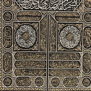 May include: Black fabric with gold and silver embroidery of Arabic calligraphy. The design features intricate patterns and geometric shapes.