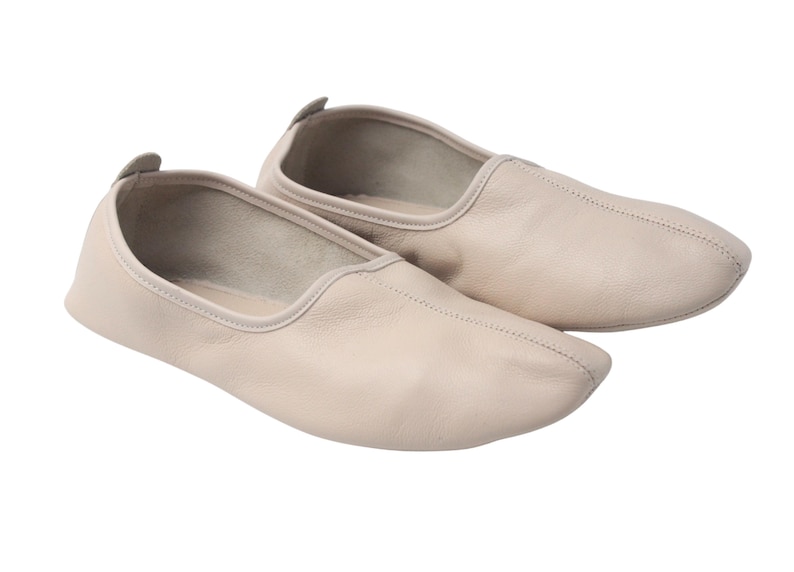 Pu&ograve; includere: Un paio di scarpette da ballo in pelle beige. Le scarpe hanno una punta arrotondata e un profilo basso, con una piccola linguetta sul tallone. Le cuciture sono visibili lungo le cuciture. Queste scarpette da ballo sono progettate per il comfort e la flessibilit&agrave;.