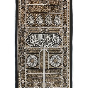May include: Black fabric wall hanging with gold and white embroidery depicting the Kaaba, a cube-shaped building in Mecca, Saudi Arabia. The embroidery features intricate Arabic calligraphy.