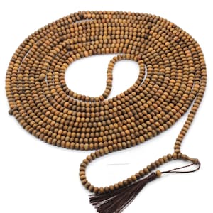 May include: A long strand of brown wooden beads with a tassel at the end. The beads are round and smooth, and the tassel is made of brown cord.