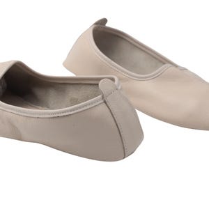 Pu&ograve; includere: Un paio di scarpette da ballo in pelle beige. Le scarpe hanno una punta arrotondata e un profilo basso, con una piccola linguetta sul tallone. Le scarpette sono progettate per il comfort e la flessibilit&agrave;, adatte alla danza o all'uso casuale.