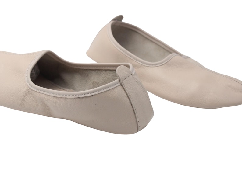 Pu&ograve; includere: Un paio di scarpette da ballo in pelle beige. Le scarpe hanno una punta arrotondata e un profilo basso, con una piccola linguetta sul tallone. Le scarpette sono progettate per il comfort e la flessibilit&agrave;, adatte alla danza o all'uso casuale.