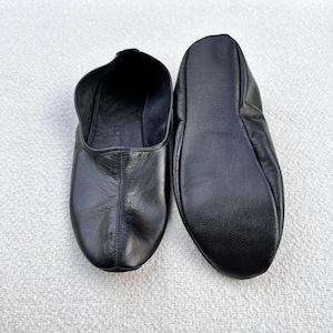 Puede incluir: Un par de zapatillas de cuero negro con punta puntiaguda. Las zapatillas est&aacute;n hechas de cuero suave y flexible y tienen un ajuste c&oacute;modo.