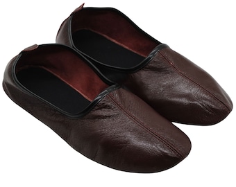 May include: A pair of brown leather slippers with black trim. The slippers have a pointed toe and a flat sole.