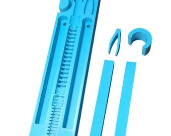 May include: A light blue plastic mold for making a 3D printed object. The mold is made up of several pieces, including a long, rectangular base with a series of grooves, two long, thin pieces, and a small, curved piece.