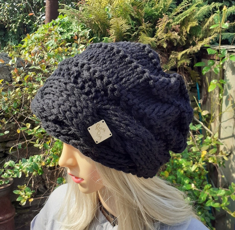 May include: Black knitted beanie with a textured pattern and a small wooden tag that says "Racing Pony".