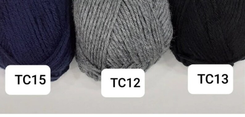 May include: Three balls of yarn in different colours: navy blue, grey, and black. The yarn balls are labelled with the codes TC15, TC12, and TC13.