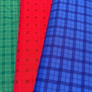 Peut inclure: Trois échantillons de tissu avec un motif à carreaux. Les échantillons sont vert, rouge et bleu.