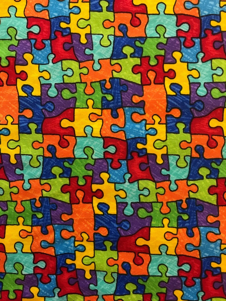 Pu&ograve; includere: Un tessuto colorato con un motivo ripetitivo di pezzi di puzzle. I pezzi del puzzle sono di vari colori, tra cui rosso, arancione, giallo, verde, blu, viola e nero. Il tessuto ha una superficie testurizzata.