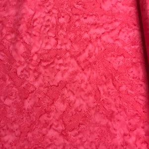 Könnte beinhalten: Nahaufnahme eines rosa Stoffes mit Marmorierung. Der Stoff hat eine weiche, glatte Textur.