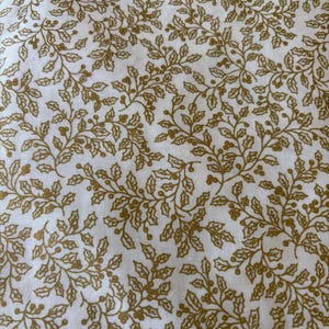 May include: White fabric with a gold floral pattern. The pattern features small leaves and berries.