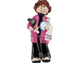 Op de afbeelding: Een roze en zwarte gepersonaliseerde kerstversiering van een kapper die een föhn, een schaar en een fles haarverf vasthoudt. De versiering is gegraveerd met de naam "Rachel" en het jaar "2020".