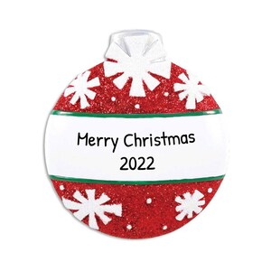 May include: Red and white Christmas ornament with a green band and the text "Merry Christmas 2022".