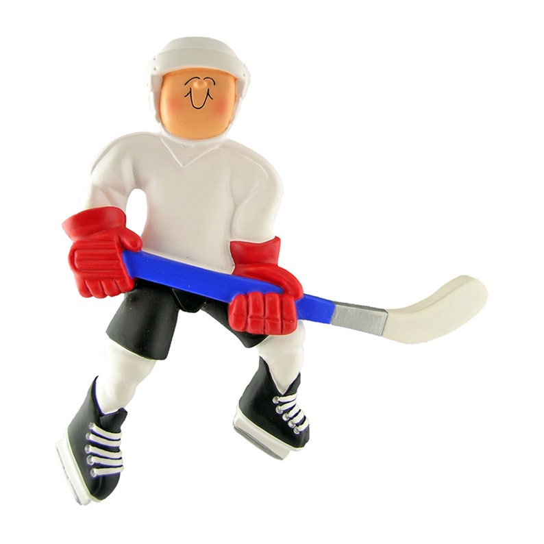 May include: A white hockey player ornament with a red and blue hockey stick. The player is wearing a white jersey, black shorts, and black skates with white laces. The player has a white helmet with a smiling face.