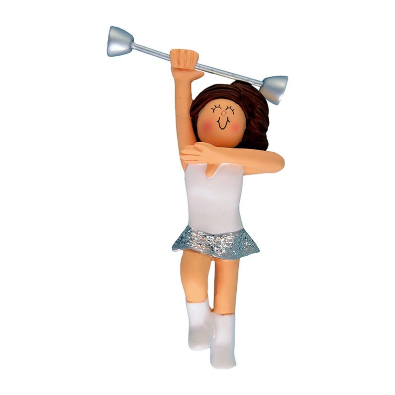 May include: A figurine of a baton twirler in a white leotard with a silver glitter skirt and white boots. The figurine has brown hair and is holding a silver baton. The figurine is on a white background.