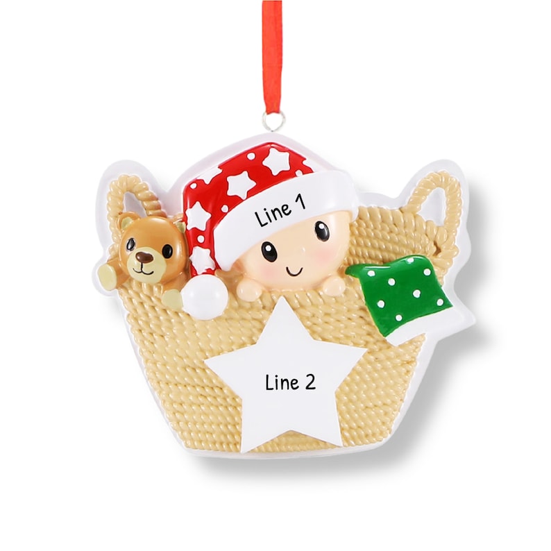 May include: A personalised Christmas bauble featuring a baby in a basket with a teddy bear. The bauble is decorated with red and white stars and has a white star in the centre with the text "Line 1" and "Line 2".