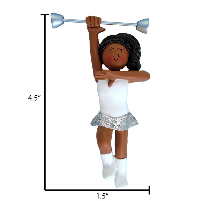May include: A brown-skinned figurine of a twirler holding a silver baton. The twirler is wearing a white leotard with a silver sequined skirt and white boots. The figurine is 4.5 inches tall and 1.5 inches wide.