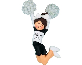May include: A black and white cheerleader ornament with pom-poms. The cheerleader is jumping in the air with her arms raised. The ornament has the name "Adelyn 2020" written on it.