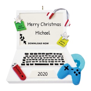 May include: A white laptop-shaped Christmas ornament with a keyboard, headphones, and a game controller. The screen reads "Merry Christmas Michael" and "Download Now." Additional details include a USB drive, a CD, and the year "2020."