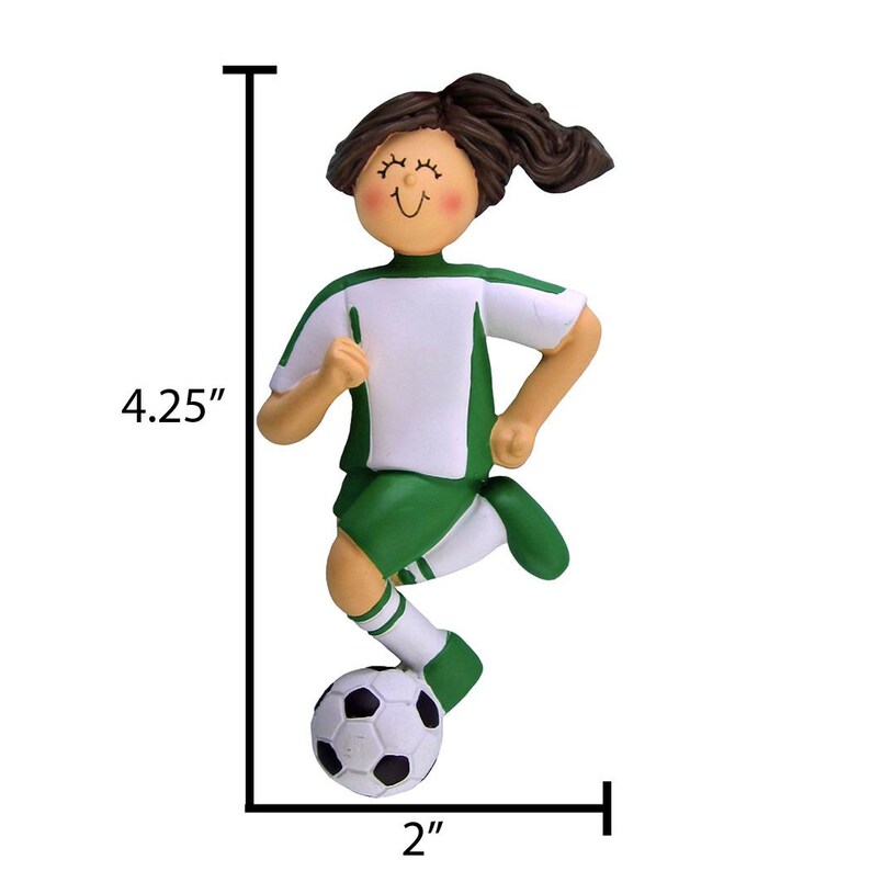May include: Green and white soccer player ornament with brown hair, smiling, kicking a black and white soccer ball. The ornament is 4.25 inches tall and 2 inches wide.